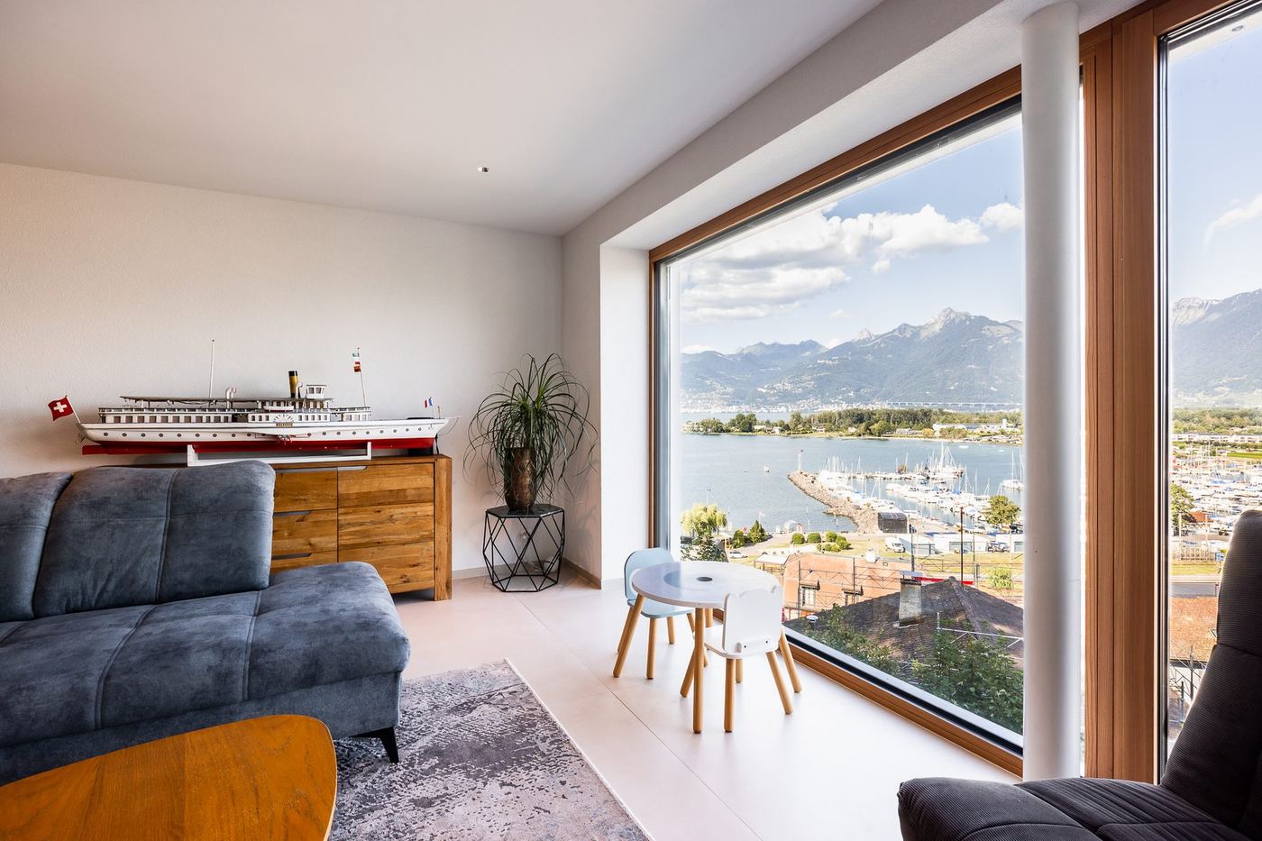 Séjour lumineux avec baie vitrée et vue sur le lac Léman — rénovation Valais